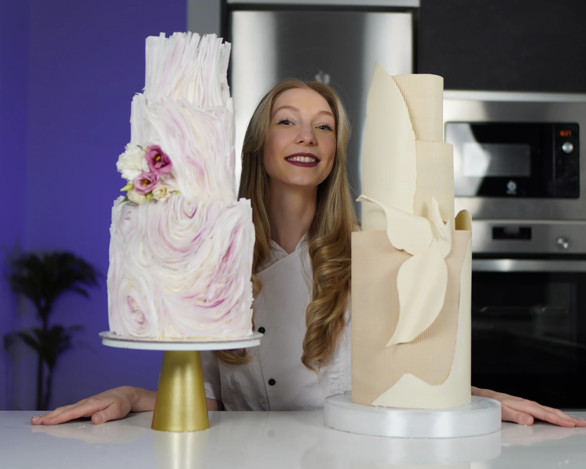 Alina Puzir en su taller, entre dos pasteles de varios pisos decorados a mano